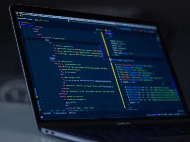 Layar laptop menampilkan kode program untuk aplikasi web custom